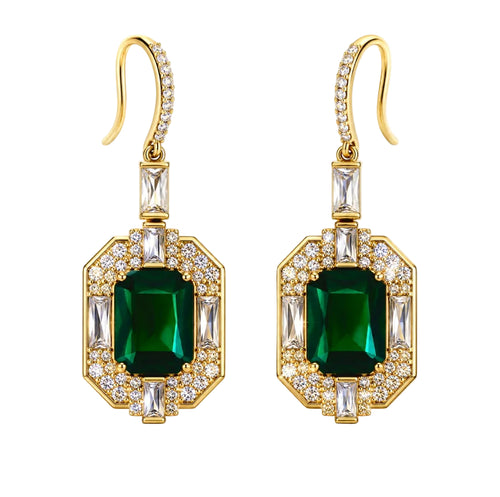 A pair of gold drop earrings featuring large emerald-cut green center stones surrounded by clear baguette and round crystals, set against a plain white background.