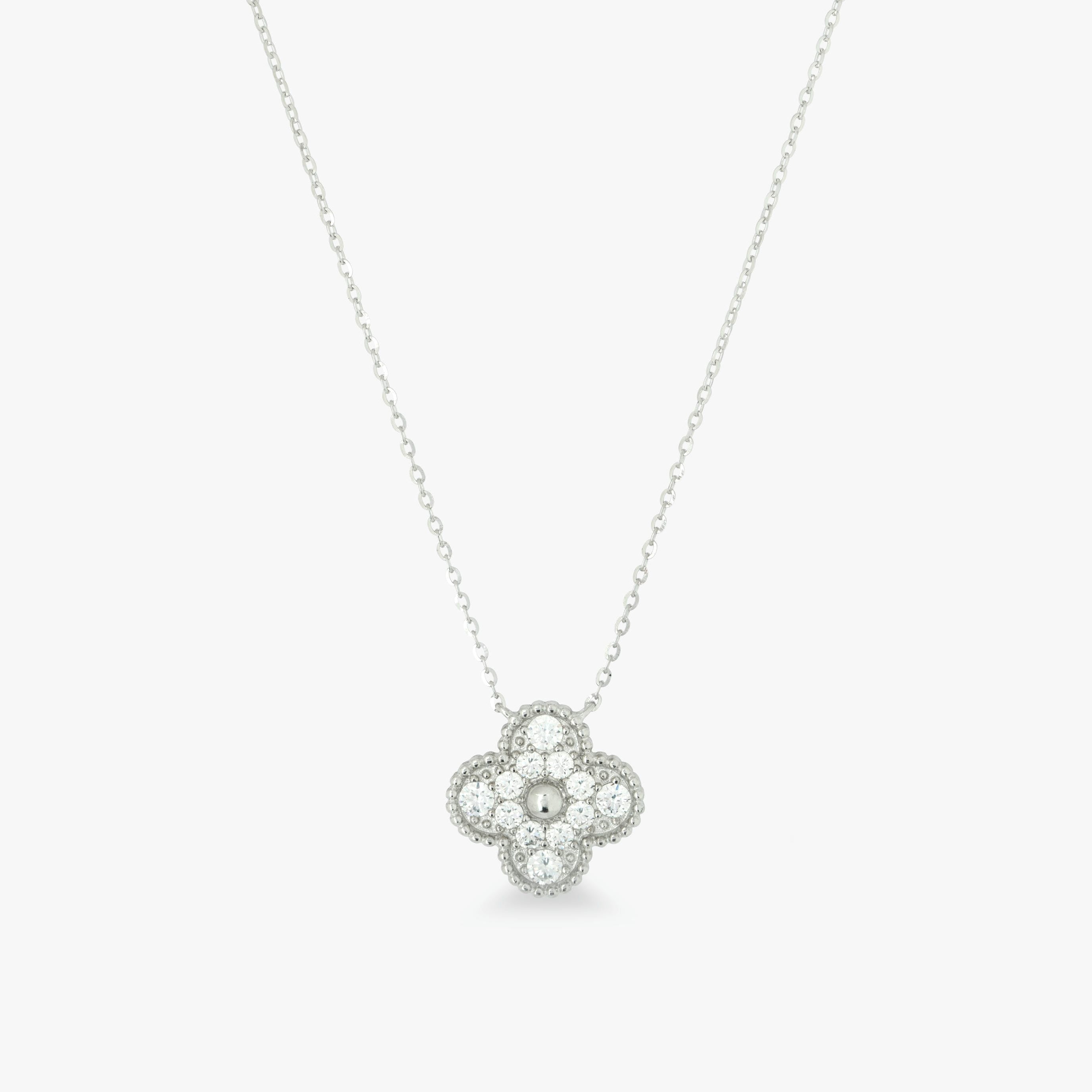 Silver necklace with a clover-shaped pendant on a light gray background