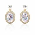 Gold earrings with large clear gemstones on a white background