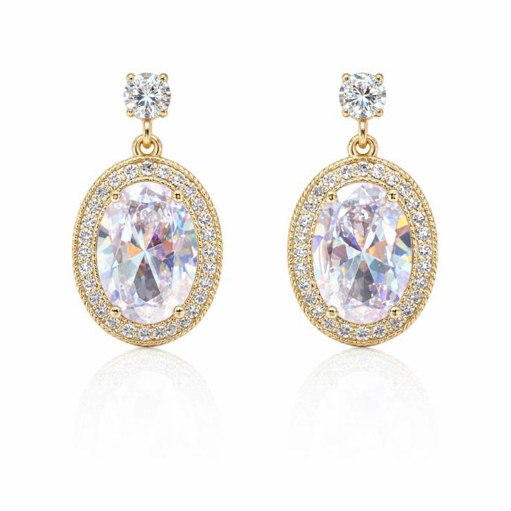 Gold earrings with large clear gemstones on a white background